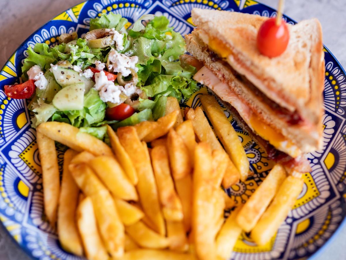 A club sandwich with chips and a side salad