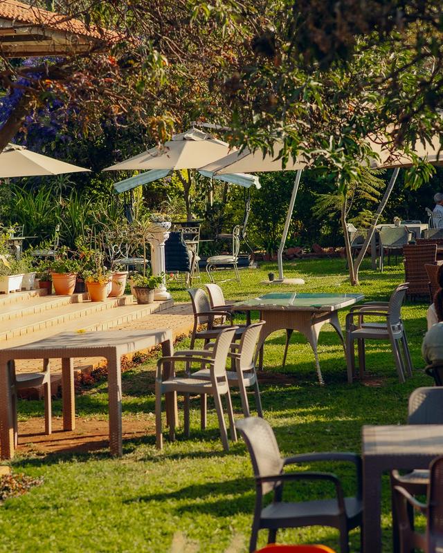 Wrought iron garden tables beneath trees in the garden